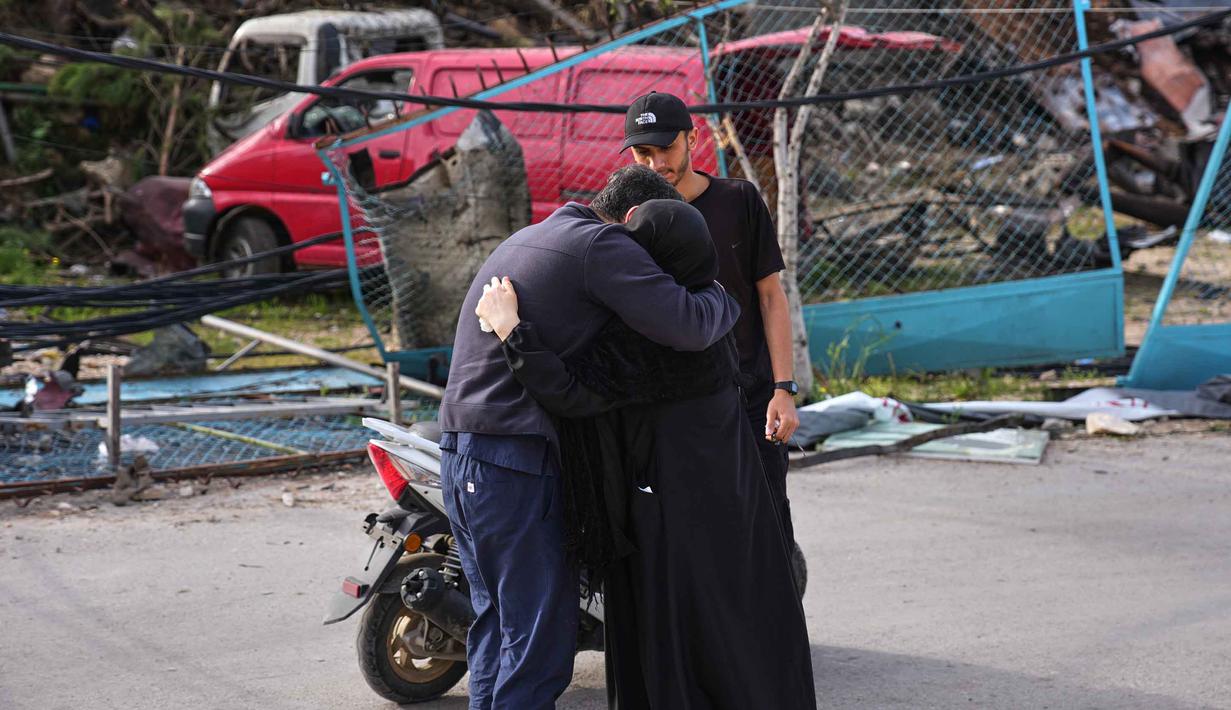 Suasana haru menyelimuti pengungsi yang kembali ke rumah-rumah mereka. Tampak dalam foto, warga setempat berpelukan di Jibchit, Lebanon selatan, Jumat 17 April 2026, setelah gencatan senjata antara Israel dan Hizbullah. (AP Photo/Hassan Ammar)