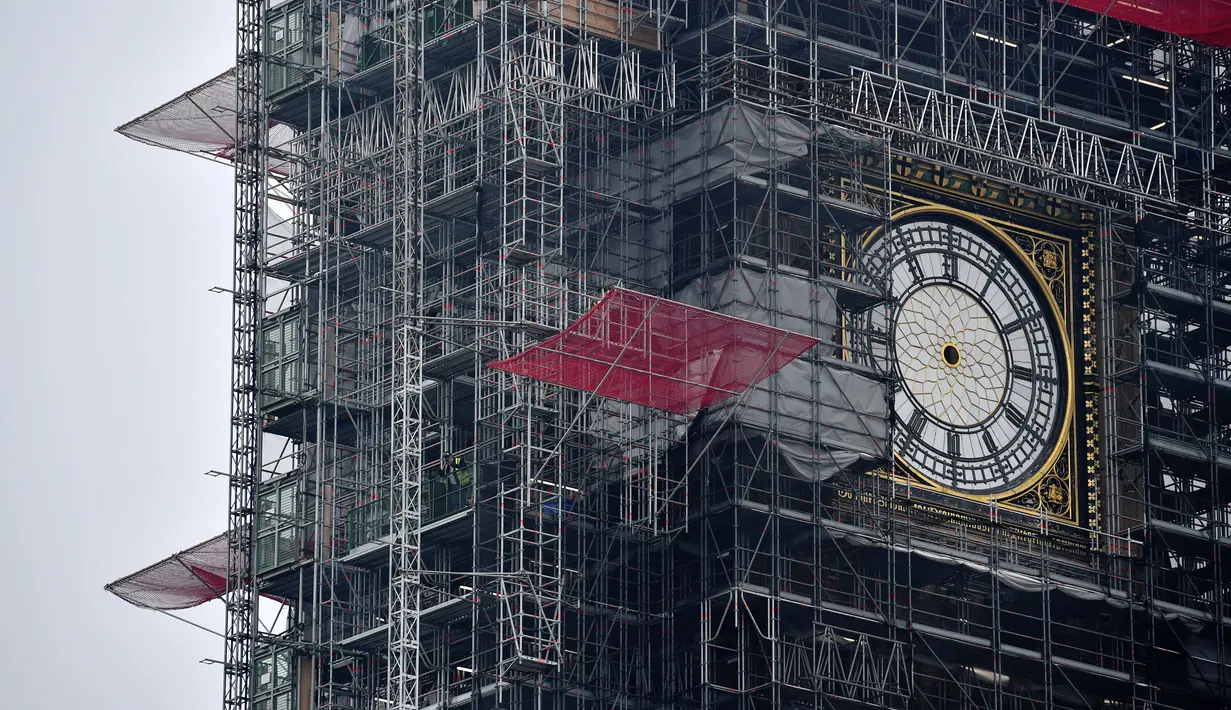 Kondisi jam Big Ben yang tidak ada jarumnya karena sedang dilakukan perbaikan dan pembersihan di London, Inggris (12/4). Jam yang berukuran seberat 13,7 ton ini akan kembali aktif dan berbunyi pada 2021. (AFP Photo/Ben Stansall)