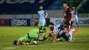 Kiper Persela Lamongan, Dwi Kuswanto (kiri) berusaha menyelamatkan bola saat menghadapi PSM Makassar dalam laga pekan ke-15 BRI Liga 1 2021/2022 di Stadion Moch. Soebroto, Magelang, Kamis (02/12/2021). (Bola.com/Bagaskara Lazuardi)