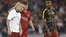 Radja Nainggolan (kiri) menerima pelukan dari rekannya Mirko Antonucci setelah laga melawan Liverpool pada semifinal Liga Champions di Olympic Stadium,(2/4/2018). AS Roma gagal ke final setelah kalah agregat dari Liverpool 6-7. (AP/Andrew Medichini)