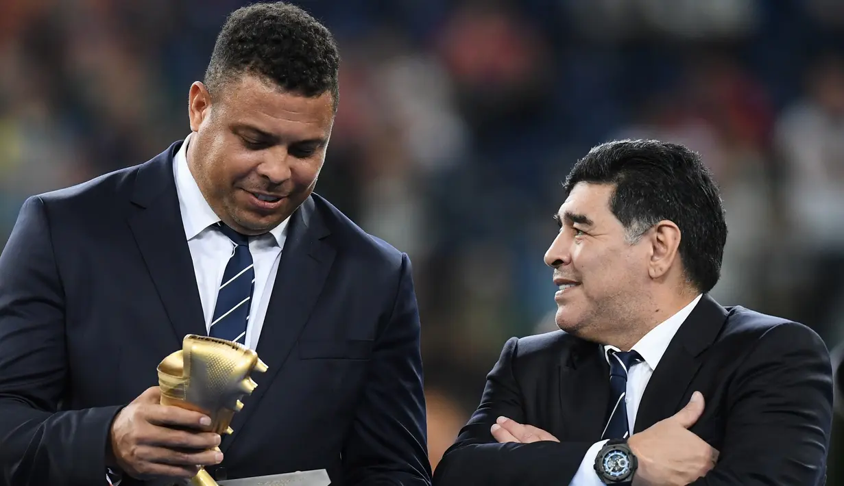 Mantan pemain Brasi, Ronaldo berbincang dengan mantan pemain Argentina, Diego Maradona saat menghadiri upacara kemenangan pertandingan final Piala Konfederasi 2017 antara Chile dan Jerman di Stadion Saint Petersburg, Rusia (2/7). (AFP Photo/Franck Fife)