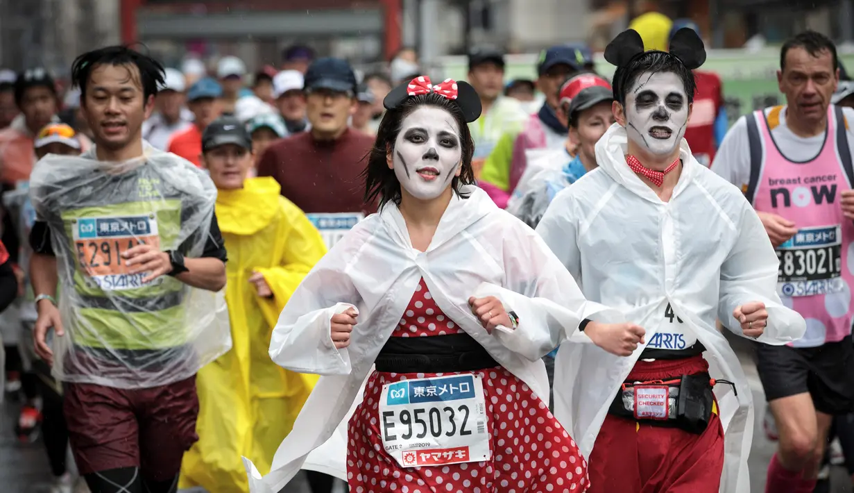Peserta mengenakan kostum karakter kartun Mickey Mouse saat berlari selama Tokyo Marathon 2019 di Jepang, Minggu (3/3). Ajang marathon terbesar ini diikuti ribuan peserta dari mancanegara. (AFP Photo/Behrouz Mehri)