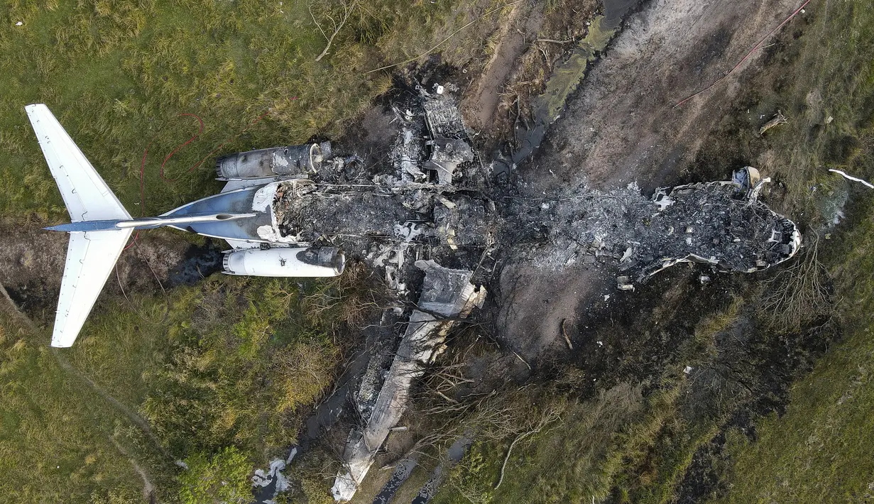 Sisa-sisa pesawat yang terbakar setelah gagal lepas landas dari Bandara Eksekutif Houston terlihat di Brookshire, Texas, Amerika Serikat, Selasa (19/10/2021). Pesawat jet pribadi tersebut mengalami kecelakaan akibat terbakar. (Godofredo A. Vásquez/Houston Chronicle via AP)