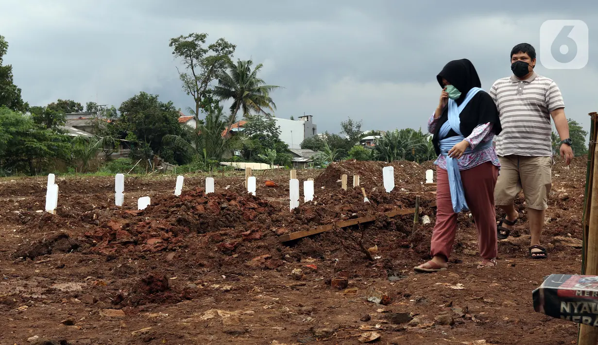 Pihak keluarga usai melakukan ziarah di area khusus pemakaman jenazah dengan protokol COVID-19 di TPU Srengseng Sawah Dua, Jakarta, Selasa, (2/2/2021). TPU Srengseng Sawah 2, saat ini mulai menerima pemakaman jenazah protokol COVID-19 dengan kapasitas 1.020 petak. (Liputan6.com/Helmi Fithriansyah)