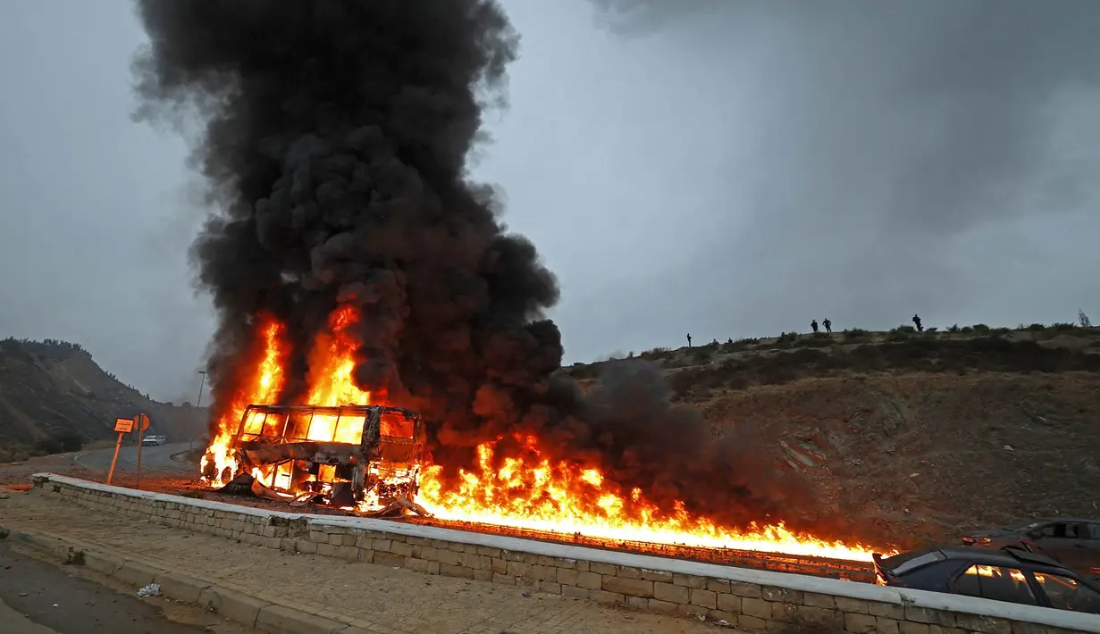 Kendaraan yang dibakar massa imigran di lokasi bentrokan dekat Fnideq, di perbatasan Maroko-Spanyol, Jumat, 31 Juli 2026. (AFP/  Abdel Majid Bziouat)