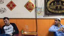 Para imigran Pakistan duduk usai menyantap makanan sahur untuk berpuasa di dalam sebuah restoran di distrik Kwai Chung, Hong Kong (25/5/2019). Luas wilayah kota ini 9,93 km². Area dalam Kwai Chung meliputi: Kwai Fong, Kwai Hing, Lai King, Tai Wo Hau. (AFP Photo/Philip Fong)
