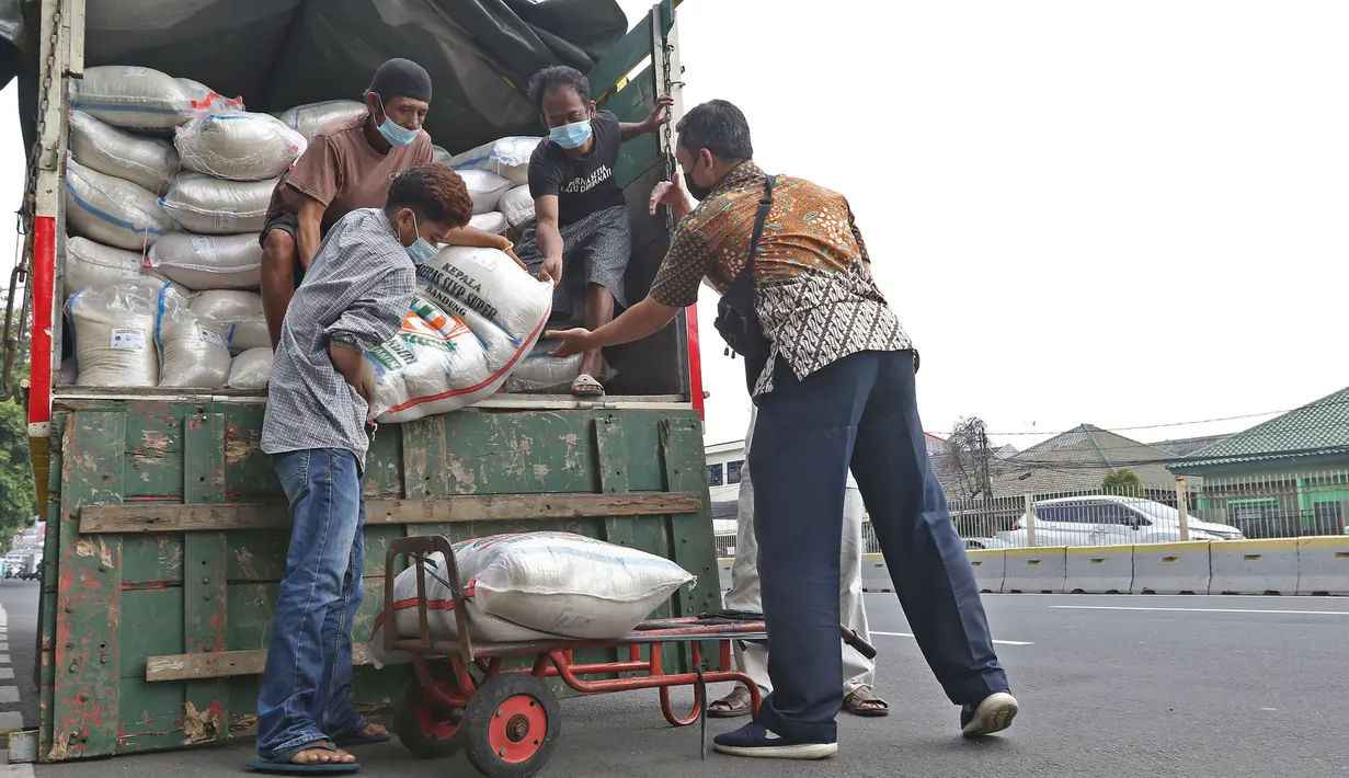 Pengurus RT memindahkan beras untuk disalurkan di kawasan RW 03 Kelurahan Tanah Tinggi, Jakarta, Kamis (29/7/2021). Bansos non tunai berupa beras didistribusikan kepada 1.007.379 Keluarga Penerima Manfaat (KPM) di lima wilayah Kota Administrasi dan Kepulauan Seribu. (Liputan6.com/Herman Zakharia)