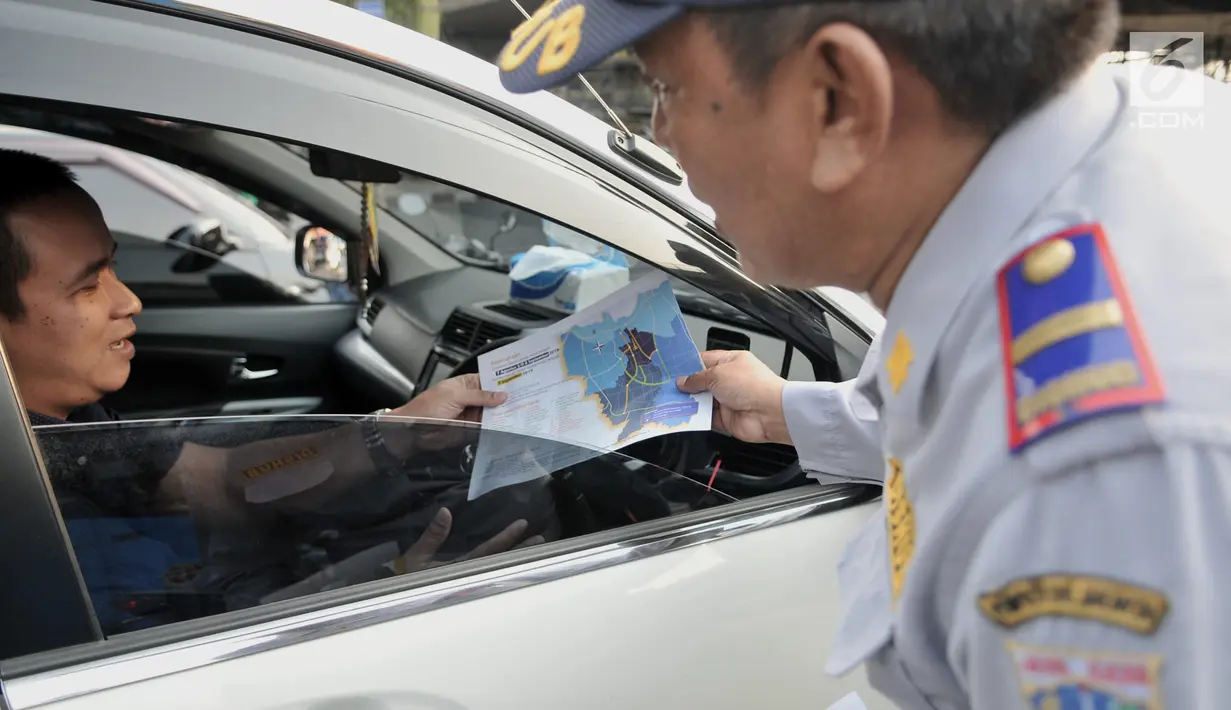 Petugas Dinas Perhubungan DKI Jakarta menunjukkan brosur kepada pengendara saat melakukan sosialisasi uji coba perluasan sistem ganjil genap di kawasan Pramuka, Jakarta, Senin (12/8/2019). Sistem ganjil genap diperpanjang mulai pukul 06.00-10.00 WIB dan 16.00-21.00 WIB. (merdeka.com/Iqbal Nugroho)