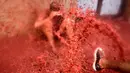 Seorang peserta mandi tomat saat mengikuti Festival Tomatina (perang tomat) di Bunol, Valencia, Spanyol, Rabu (31/8). Sekitar 170 ton atau 175 ribu kilogram tomat matang digunakan untuk acara Perang Tomat tersebut. (REUTERS / Heino Kalis)