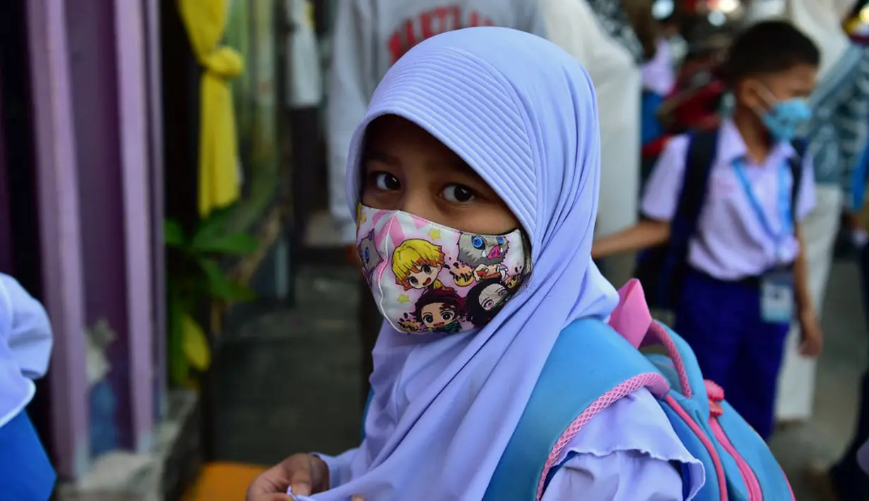 Seorang siswa tiba di Sekolah Pimarnvit, Provinsi Narathiwat, Thailand, 20 Mei 2022. Thailand melanjutkan sekolah tatap muka secara nasional untuk tahun ajaran baru setelah bertahun-tahun terganggu karena pandemi COVID-19. (Madaree TOHLALA/AFP)