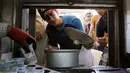 Seorang pria ketika menerima makanan buka puasa gratis yang didistribusikan bagi yang membutuhkan selama bulan puasa di masjid Abdul Qadir al-Gailani, Baghdad, Rabu (24/6/2015). (REUTERS/Khalid al-Mousily)