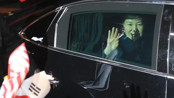 Mantan Presiden Korea Selatan (Korsel) Park Geun-hye melambaikan tangan dari dalam mobil setibanya di rumah pribadinya di Seoul, Minggu (12/3). Geun-hye meninggalkan Blue House setelah resmi dimakzulkan Mahkamah Konstitusi (MK) Korsel. (str/YONHAP/AFP)