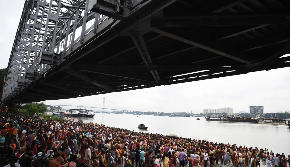 Ratusan umat Hindu berkumpul untuk mengikuti ritual 'Tarpan' untuk mempersembahkan doa kepada leluhur mereka pada hari terakhir Pitrupaksh di tepian Sungai Gangga di Kolkata (19/9). (AFP Photo/Dibyangshu Sarkar)