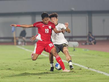Pemain Timnas Indonesia U-17, Sean Rahman berduel dengan pemain China U-17, Kuang Zholei dalam pertandingan uji coba internasional di Indomilk Arena, Tangerang, pada Rabu (11/2/2026) malam WIB. (Bola.com/Abdul Aziz)