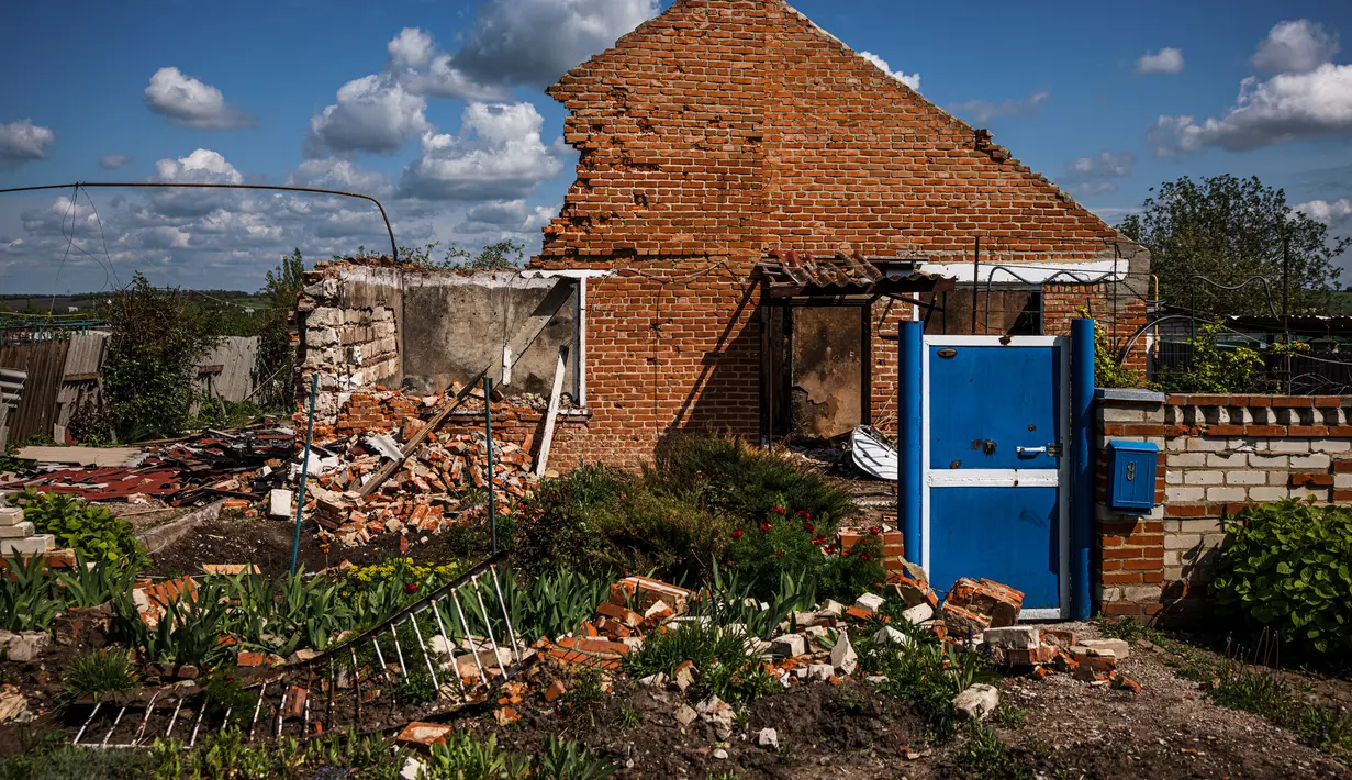 <p>Sebuah foto menunjukkan bangunan rumah yang hancur, di tengah invasi Rusia ke Ukraina, di desa Vilkhivka, dekat kota timur Kharkiv, pada 14 Mei 2022. Puluhan rumah di Vilkhivka, sebuah desa berpenduduk sekitar 2.000 jiwa, hancur oleh peluru, ledakan atau kebakaran. Puing-puing berserakan di jalan-jalan termasuk selongsong peluru, dan sisa-sisa amunisi. (Dimitar DILKOFF / AFP)</p>
