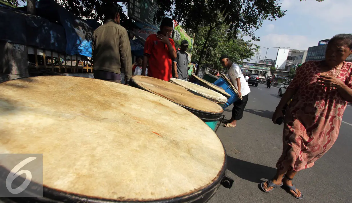 Seorang warga tampak melintas di depan penjualan bedug di kawasan Tanah Abang, Jakarta, Kamis,(16/7/2015). Harga bedug berkisar Rp.200-700 Ribu tergantung ukuran. (Liputan6.com/Helmi Afandi)