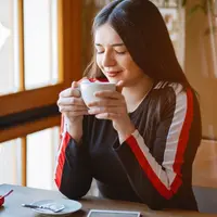Seorang perempuan sedang me time di sebuah cafe (Foto Dok: Freepik/prostooleh).