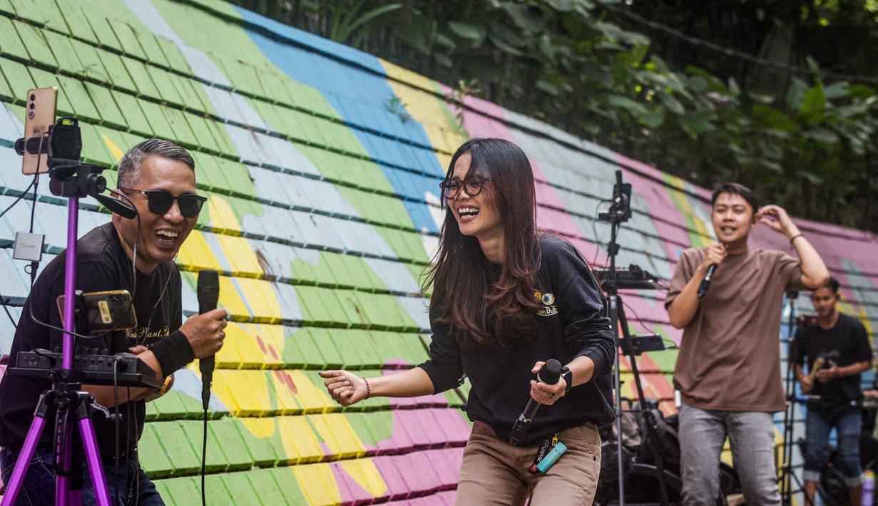 Mereka menjadikan media sosial sebagai wadah utama untuk unjuk bakat, berinteraksi, dan membangun karier. Tampak dalam foto, para penyanyi dalam jaringan (daring/online) menggunakan dinding berwarna-warni sebagai latar belakang tampil untuk menarik penonton agar memberikan donasi digital selama siaran langsung mereka di situs media sosial, Bandung, Jawa Barat, pada Jumat 8 Mei 2026. (Timur Matahari/AFP)