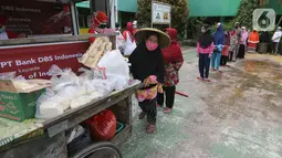 Warga terdampak Covid-19 antre mendapatkan paket makanan di Cipulir, Jakarta Jumat (18/12/2020). Bantuan langsung kepada 8.000 kepala keluarga disalurkan melalui Foodbank of Indonesia (FOI) sebagai kelanjutan dari kampanye “DBS Stronger Together Fund”. (Liputan6.com/Fery Pradolo)