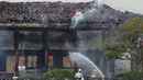 Petugas pemadam kebakaran berusaha memadamkan api yang membakar Kastil Shuri di Okinawa, Jepang selatan, Kamis (31/10/2019). Aula utama kastil yang dibangun dari kayu tersebut dilaporkan hangus tinggal rangka bangunan. (Jun Hirata/Kyodo News via AP)