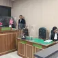Terdakwa Haris Sitanggang mantan anggota Densus 88 Polri berdiskusi dengan kuasa hukumnya pada persidangan kasus pembunuhan sopir taksi online di Pengadilan Negeri Depok. (Liputan6.com/Dicky Agung Prihanto)