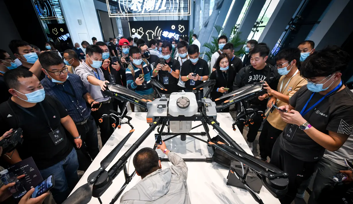 Pengunjung melihat T30, drone perlindungan tanaman baru DJI, usai upacara peluncuran produk di Shenzhen, Provinsi Guangdong, China selatan (9/11/2020). DJI, perusahaan produsen drone China, meluncurkan dua drone perlindungan tanaman baru, yakni T30 dan T10, di Shenzhen. (Xinhua/Mao Siqian)