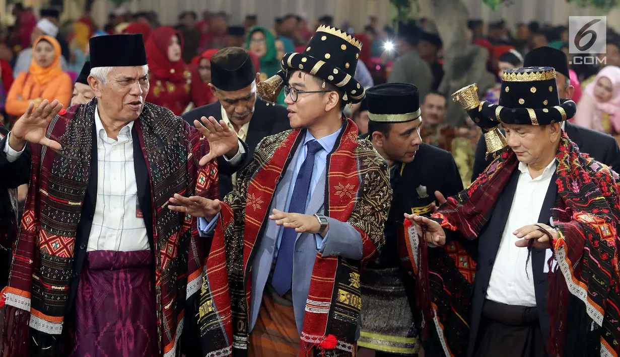 Putra sulung Jokowi, Gibran Rakabuming saat menari Tortor saat acara adat pernikahan Kahiyang Ayu dan Bobby Nasution di BHR Tasbi, Medan (24/11). Gibran Rakabuming menggunakan topi khas adat Mandailing dan ulos. (Liputan6.com/Pool/Media Center)