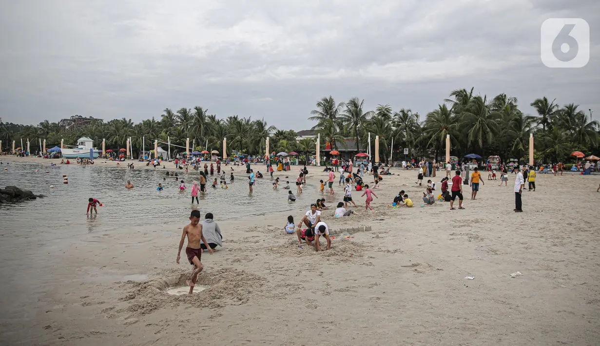 Pengujung berwisata di Pantai Ancol, Jakarta, Rabu (28/12/2022). Isu cuaca yang kurang bersahabat pada hari ini, tidak menyurutkan keinginan warga menghabiskan libur untuk berwisata di kawasan wisata Ancol. (Liputan6.com/Faizal Fanani)