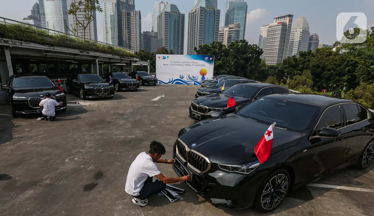 Petugas membersihkan mobil BMW i7 dan i5 di komplek GBK, Senayan, Jakarta, Jumat (3/5/2024). (Liputan6.com/Angga Yuniar)