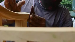 Pekerja menghaluskan furnitur atau perlengkapan rumah berbahan kayu dari Jepara di Ciputat, Tangerang Selatan, Selasa (14/9/2021). Pedagang di tempat tersebut mengakui selama PPKM ini daya beli masyarakat terhadap furnitur meningkat. (Liputan6.com/Johan Tallo)