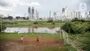 Sejumlah anak bermain di lapangan bola yang terdapat di Bantaran Banjir Kanal Barat Kawasan Petamburan, Jakarta, Minggu (12/12/2021). Taman di bantaran kali kawasan padat penduduk itu menjadi sarana bermain bagi anak-anak di sekitarnya. (Liputan6.com/Faizal Fanani)