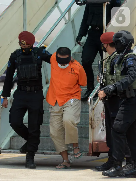 Anggota Densus 88 Antiteror menggiring terduga teroris turun dari pesawat saat tiba di Bandara Soekarno-Hatta, Tangerang, Banten, Kamis (18/3/2021). Polri memindahkan 22 terduga teroris jaringan kelompok Jamaah Islamiyah (JI) dari Jawa Timur ke Jakarta. (merdeka.com/Imam Buhori)