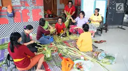 Sejumlah ibu serati banten mempersiapkan Gebogan yang akan digunakan dalam upacara Mecaru dalam menyambut perayaan hari Raya Nyepi dan Tahun baru Saka 1941 di Pura Tribhuana Agung Sukmajaya Depok, Jawa Barat, Selasa (5/3). (Liputan6.com/Herman Zakharia)