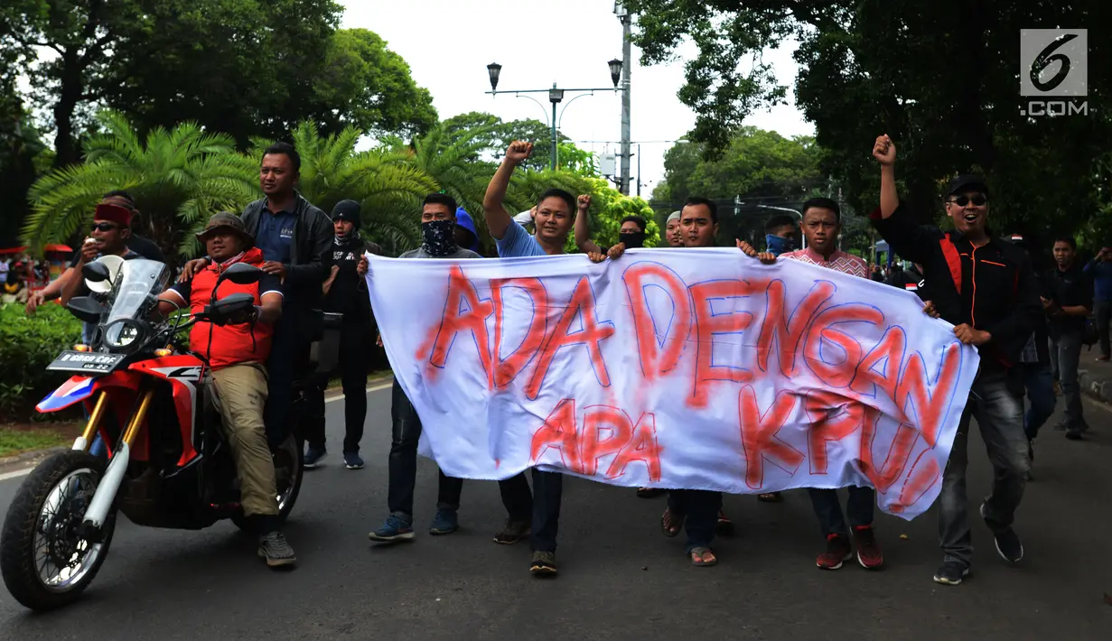 Sejumlah massa membentangkan spanduk saat simulasi pengamanan Pemilu 2019 di depan Kantor KPU, Jakarta, Sabtu (16/3). Simulasi dalam rangka persiapan mengamankan Pilpres serta pemilihan legislatif pada 17 April mendatang. (merdeka.com/Imam Buhori)