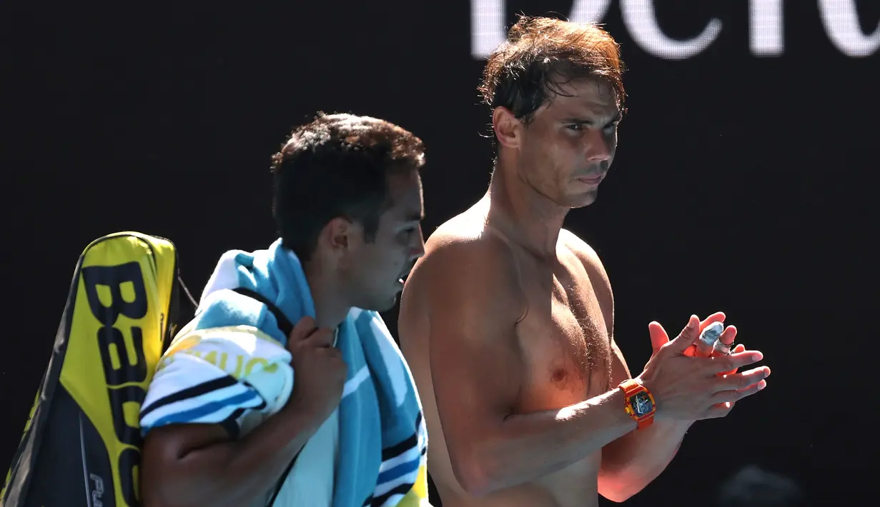 Petenis Rafael Nadal (kanan) dan Hugo Dellien meninggalkan Rod Laver Arena setelah pertandingan tunggal putra putaran pertama kejuaraan tenis Australia Terbuka di Melbourne, Australia, Selasa (21/1/2020). Nadal mengalahkan Dellien dan melaju ke putaran kedua Australia Terbuka. (AP Photo/Lee Jin-man)