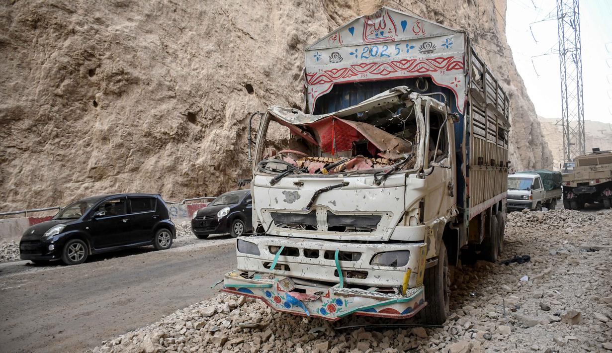Sebuah truk yang rusak di sepanjang jalan raya terlihat setelah gempa bumi di Tang-e Tashkurgan, distrik Khulm, provinsi Samangan, pada Senin 3 November 2025. Untuk diketahui, Afghanistan merupakan wilayah rawan gempa bumi karena terletak di atas sejumlah jalur patahan, tempat pertemuan lempeng tektonik India dan Eurasia. (Atif Aryan/AFP)