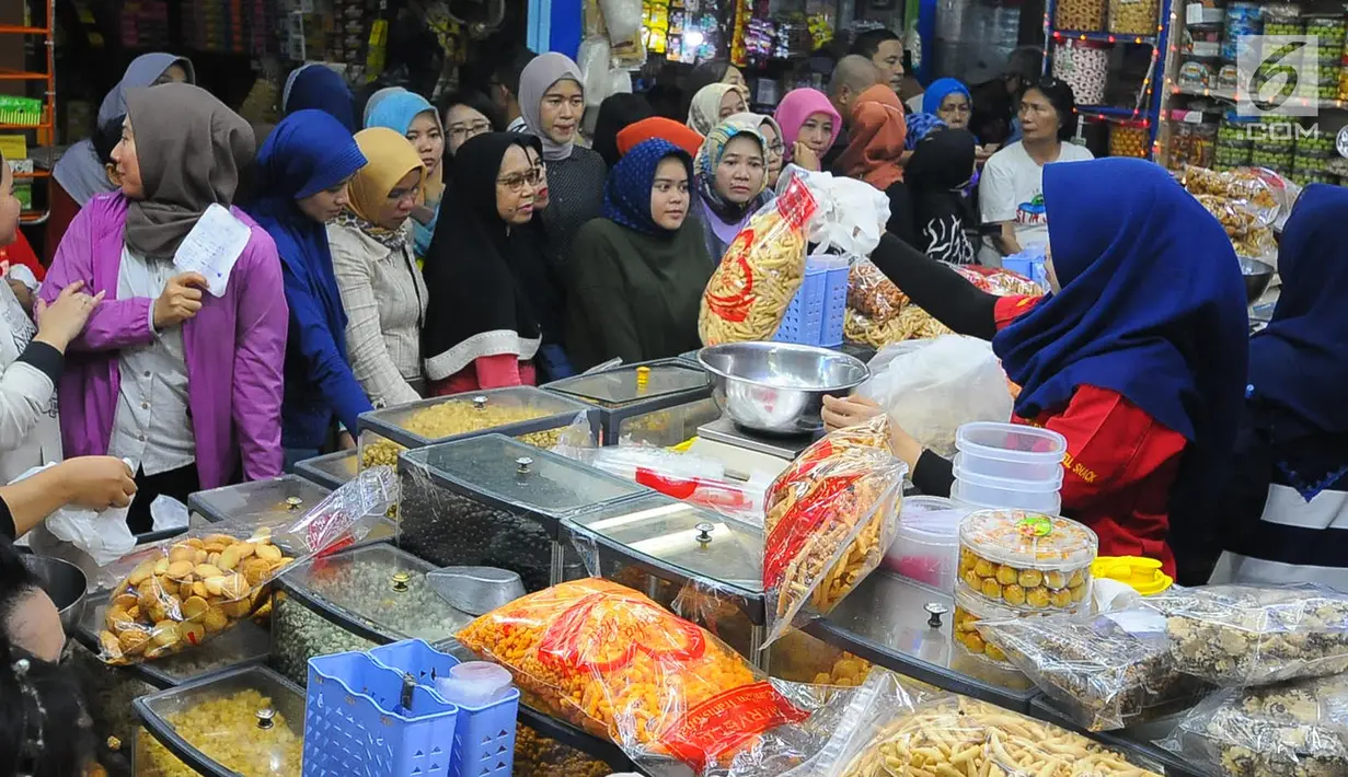 Sejumlah pembeli mengantre saat membeli kue kering di Pasar Jatinegara, Jakarta, Senin (27/5/2019). Jelang Idul Fitri 2019, banyak warga berburu makanan ringan seperti kue kering untuk jamuan di hari raya. (Liputan6.com/Angga Yuniar)