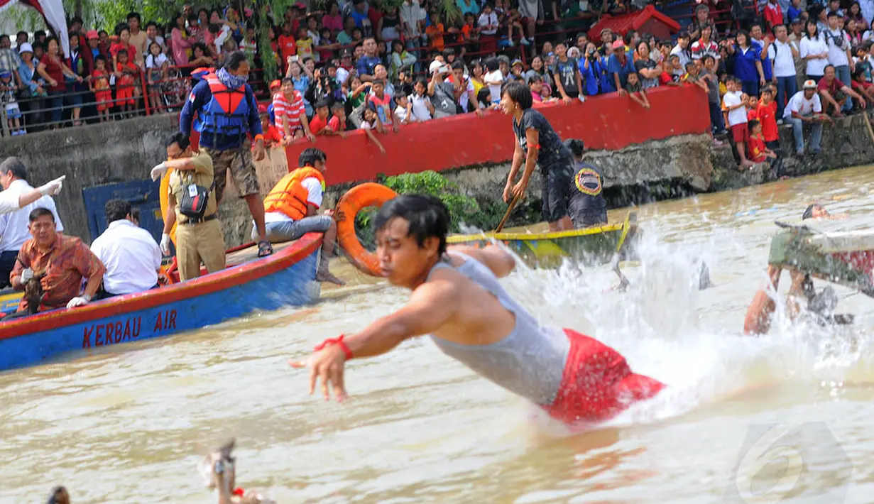 Warga Tangerang tampak asyik menyaksikan perlombaan tangkap bebek di bibir Sungai Cisadane, Kota Tangerang, Senin (2/6/14). (Liputan6.com/Faisal R Syam)