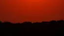 Orang-orang menyaksikan matahari terbenam sambil berperahu di Shawnee Mission Lake, Shawnee, Kansas, Amerika Serikat, Jumat (9/10/2020). Matahari terbenam terus lebih cerah dari biasanya karena asap dari kebakaran hutan barat terus melayang di seluruh negeri. (AP Photo/Charlie Riedel)