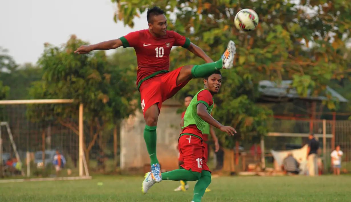 Timnas Indonesia U-23 kembali melakukan latihan di Lapangan Sutasoma Halim Perdanakusuma, Jakarta, Sabtu (23/5/2015). Tampak, penggawa timnas U-23, Wawan Pebrianto melompat menahan bola yang mengarah ke Manahati Lestusen. (Liputan6.com/Helmi Fithriansyah)