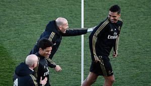 Pelatih Real Madrid, Zinedine Zidane dan gelandang timnya, Casemiro bercanda selama sesi latihan terbuka untuk umum di fasilitas latihan Ciudad Real Madrid, Valdebebas, Senin (30/12/2019). Real Madrid akan menghadapi Getafe pada pertandingan La Liga di laga pembuka tahun 2020. (OSCAR DEL POZO/AFP)