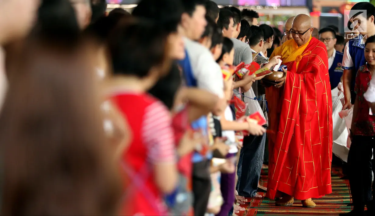 Umat Buddha memberikan angpao saat merayakan Hari Raya Waisak 2562 BE/2018 di Wihara Ekayana Arama, Jakarta Barat, Selasa (29/5). Puja Bakti Massal Waisak 2562 BE diikuti oleh ribuan umat Buddha. (Liputan6.com/JohanTallo)