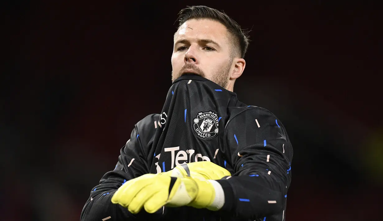 Kiper Manchester United, Jack Butland melakukan pemanasan jelang laga perempatfinal Piala Liga 2022/2023 menghadapi Charlton Athletic di Old Trafford Stadium, Manchester (10/1/2023). Didatangkan dengan status pinjaman selama setengah musim dari Crystal Palace pada Januari 2023 untuk melapis David De Gea, Jack Butland nyatanya hingga kini belum pernah sekalipun dimainkan pelatih Erik ten Hag. Besar kemungkinan ia akan dikembalikan ke Crystal Palace akhir musim ini. (AFP/Oli Scarff)