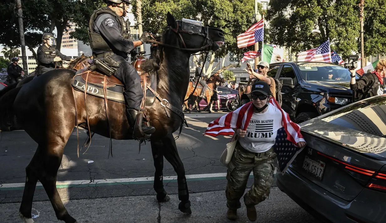 Kepolisian Los Angeles juga menyatakan pihaknya telah melakukan penangkapan terhadap sejumlah orang yang nekat melanjutkan protes saat jam malam berlaku. (RONALDO SCHEMIDT/AFP)