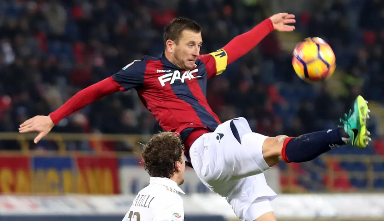 Aksi kapten Bologna, Daniele Gastaldello (kanan) menghalau bola dari kejaran pemain AC Milan pada laga Serie A di di Stadio Renato Dell'Ara, Bologna,  (8/5/2/2017).  MIlan mengan 1-0. (EPA/Giorgio Benvenuti)