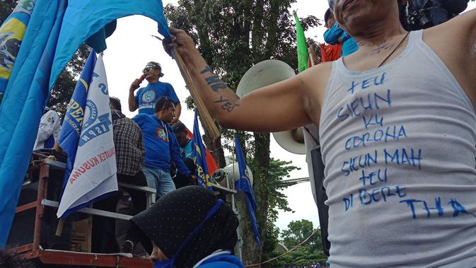 Aliansi Buruh se-Jawa Barat yang terdiri dari 21 serikat pekerja menggelar demonstrasi menolak pengesahan Omnibus Law Rancangan Undang-Undang (RUU) Cipta Kerja di depan Gedung Sate, Kota Bandung, Senin (16/3/2020). (Liputan6.com/Huyogo Simbolon)