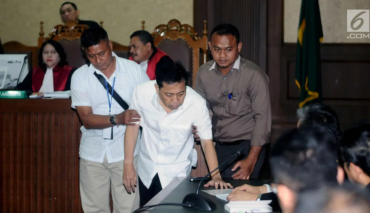 Tersangka korupsi proyek E-KTP Setya Novanto digiring masuk ruang persidangan di Pengadilan Tipikor, Jakarta, Rabu (13/12). Sidang diskors untuk melakukan pemeriksaan kesehatan terhadap Setya Novanto. (Liputan6.com/Helmi Fithriansyah)