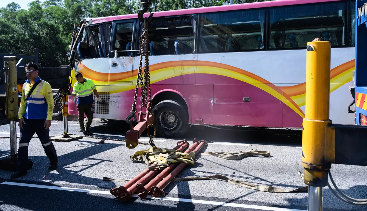 Sejumlah petugas mengevakuasi sebuah bus setelah bertabrakan dengan taksi di Hong Kong (30/11). Lima orang tewas dan 32 luka-luka setelah akibat kecelakaan tersebut. (AFP Photo/Anthony Wallace)