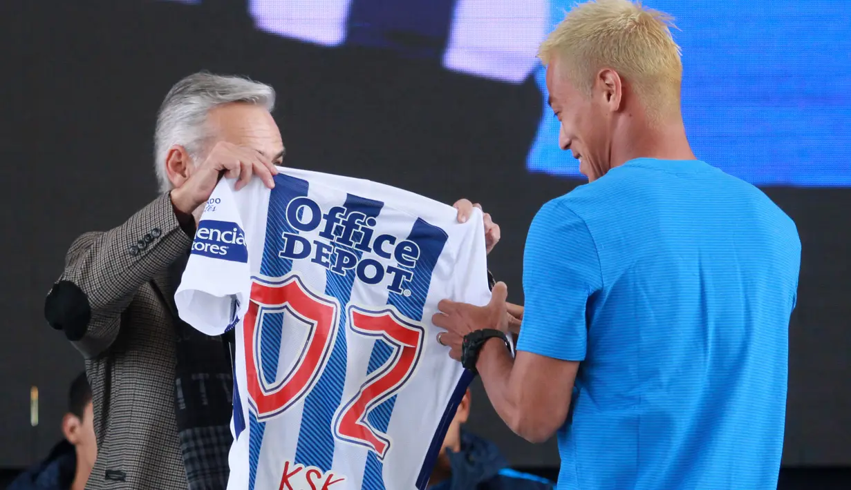 Presiden klub Pachuca, Jesus Martinez memberikan jersey kepada gelandang asal Jepang, Keisuke Honda saat diperkenalkan sebagai pemain baru Pachuca  di Football University, Pachuca, Meksiko, (18/7). (AFP Photo/Victor Cruz)