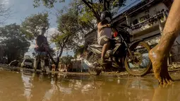 Warga berjalan di sebuah jalan yang tertutup lumpur akibat banjir yang dipicu Topan Vamco di Manila, Filipina (13/11/2020). Pemerintah Filipina pada Jumat (13/11) mengatakan Topan Vamco, yang memicu banjir besar dan tanah longsor menelan sedikitnya 14 korban jiwa. (Xinhua/Rouelle Umali)